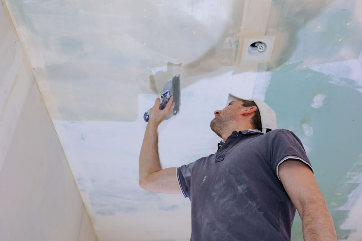 Trabajador pintando el techo